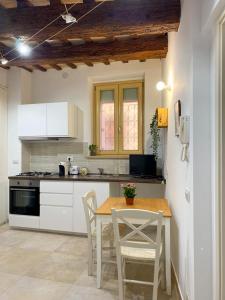 レカナーティにあるLa Casa di LEO - Apartmentsのキッチン(テーブル、椅子、コンロ付)