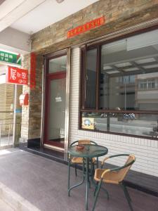 a table and two chairs sitting outside of a building at 居歇座民宿 in Magong