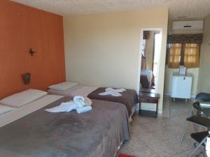 a hotel room with two beds with towels on them at Hotel Pousada Viking in Jacumã