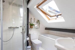 ein Badezimmer mit einem Waschbecken, einem WC und einem Dachfenster in der Unterkunft Stunning character 2bed Cottage in St Albans Wifi in St Albans + 18 Fotos