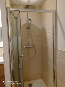 La salle de bains est pourvue d'une douche avec une porte en verre. dans l'établissement AppartHôtel, à Poitiers