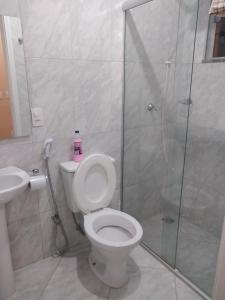 een badkamer met een douche, een toilet en een wastafel bij chalés duas irmãs in Serra Negra
