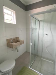 a bathroom with a shower and a toilet and a sink at Pousada Sertaneja in Canindé de São Francisco