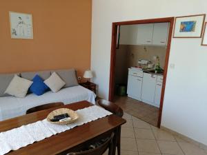 een kamer met een bed, een tafel en een keuken bij Apartments Stjepic in Sukošan