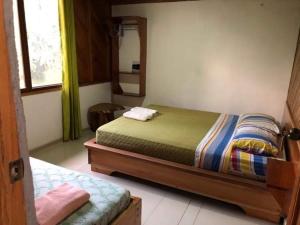 1 dormitorio con cama y espejo en Coatí Lodge Misahuallí - FamiliyJungleParadise, en Puerto Misahuallí