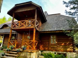 a log cabin with a porch and stairs in front of it at Myszówka 