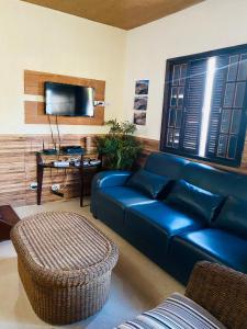 sala de estar con sofá azul y mesa en Casa Amarela, en Arraial do Cabo