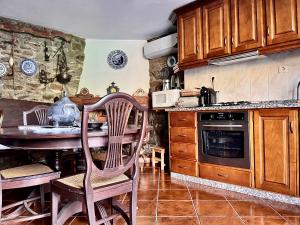 a kitchen with wooden cabinets and a table with chairs at Casa da Barriada I in Bragança
