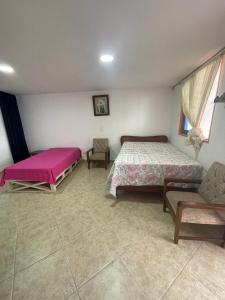 1 Schlafzimmer mit 2 Betten, einem Sofa und einem Fenster in der Unterkunft Villa Chela, Hermosa casa de descanso, Venecia Antioquia in Venecia