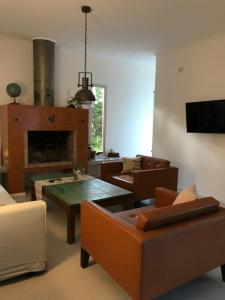 sala de estar con sofás, mesa y chimenea en Casona alegre con pileta y patio en San Pedro