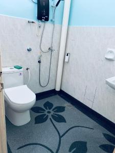 a bathroom with a shower and a toilet with a flower on the floor at Casa Drezqi Homestay Melaka Private Pool in Melaka