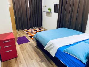 a bedroom with a blue bed and a red dresser at Casa Drezqi Homestay Melaka Private Pool in Melaka +10 photos