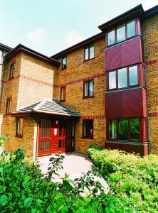 a large brick building with a red door at Quayside Close Holiday Apartments in Poole