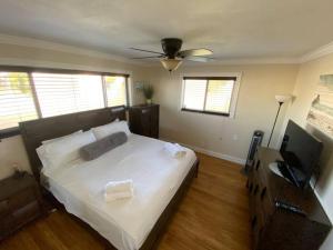a bedroom with a bed and a flat screen tv at Visit Pomtuga and leave your worries behind in Pompano Beach