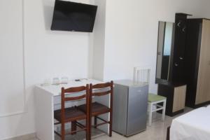 a small kitchen with a table and chairs and a television at Hotel Tirona in Durrës