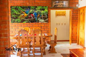 a dining room with a table and a painting on the wall at Hostal San Jorge in Pereira