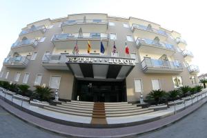 a large building with flags in front of it at Hotel Luxor in Casoria