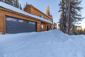 una casa de madera con garaje en la nieve en Beautiful New Construction Home with Great Views and Pool Table - Silverheels Chalet, en Fairplay