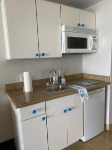 a kitchen with a sink and a microwave at OC North Beach ocean front condo with spectacular views in Hampton