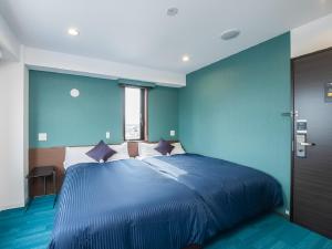 1 dormitorio azul con 1 cama grande y paredes azules en HOTEL LiVEMAX Gifu Ekimae en Gifu