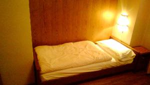 a small bed in a room with a light on it at Campiglio Trilocale Monte Spinale in Madonna di Campiglio