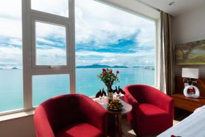 Habitación con 2 sillas rojas y ventana grande. en Nha Trang Wonderland Hotel, en Nha Trang