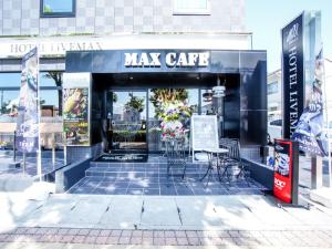 a maj cafe with tables and chairs in front of a building at HOTEL LiVEMAX Gifu Hashima Ekimae in Hashima