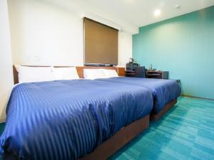 Un pat sau paturi într-o cameră la HOTEL LiVEMAX Gifu Hashima Ekimae