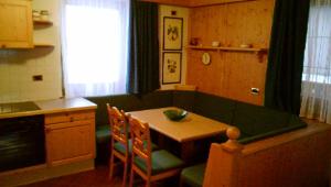 salon ze stołem i zieloną kanapą w obiekcie Campiglio Trilocale Dolomiti w Madonna di Campiglio