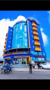 Ein blaues Gebäude mit Leuten, die davor stehen. in der Unterkunft Marriot Metropolitan Hotel in Douala
