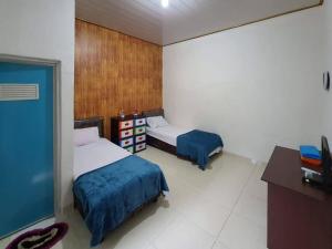 a bedroom with two beds and a desk and a tv at RedDoorz Syariah at Labuhan Maringgai Lampung in Mataram-baru +16 photos