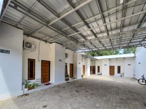 a large room with white walls and a metal ceiling at RedDoorz Syariah at Labuhan Maringgai Lampung in Mataram-baru