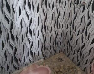 a bathroom with a white and black wall at RedDoorz Syariah at Labuhan Maringgai Lampung in Mataram-baru