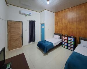 a bedroom with a bed and a wooden wall at RedDoorz Syariah at Labuhan Maringgai Lampung in Mataram-baru