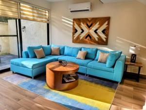 Amazing Dream Home in Gated Community في بلايا ديل كارمن: غرفة معيشة مع أريكة زرقاء وطاولة