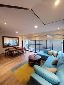 a living room with a blue couch and a table at Amazing Dream Home in Gated Community in Playa del Carmen