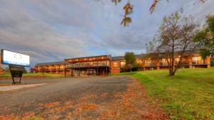 un gran edificio con un cartel delante en Blue Jacket Motel, en Canowindra