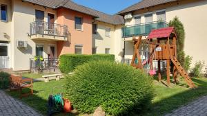 un parque infantil en un patio junto a un edificio en Amulett Suite Apartment, en Hajdúszoboszló