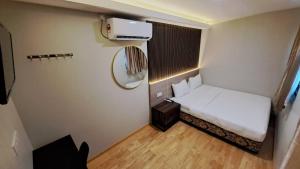um pequeno quarto com uma cama e um espelho em Tc theme park Guest house em Kuantan