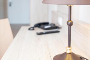 uma lâmpada sentada numa mesa ao lado de um telefone em Aparthotel Altomünster - Garni em Altomünster