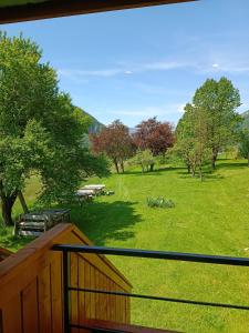 a deck with a view of a park with trees at Apartmaji Hodak in Bohinj