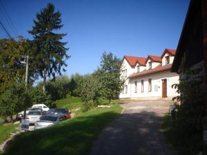 a large white building with cars parked in front of it at Penzion Pod Vyhlídkou in Pecka