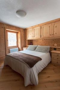 um quarto com uma cama grande e uma janela em NUOVISSIMO appartamento a due passi da Bormio! em Valfurva