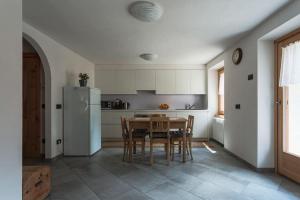 uma cozinha com uma mesa e cadeiras e um frigorífico em NUOVISSIMO appartamento a due passi da Bormio! em Valfurva