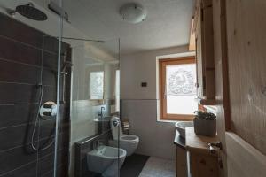 uma casa de banho com um chuveiro, um WC e um lavatório. em NUOVISSIMO appartamento a due passi da Bormio! em Valfurva