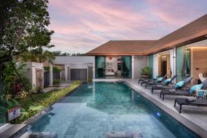 a swimming pool in a villa with lounge chairs at Inspire Villas Phuket in Rawai Beach