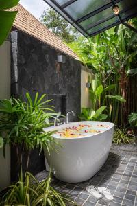 y baño con bañera en el jardín. en Inspire Villas Phuket en Rawai Beach