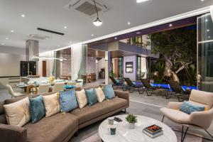 a living room with a couch and tables and chairs at Inspire Villas Phuket in Rawai Beach