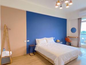 三星鄉的住宿－遇稻包棟民宿，一间卧室设有蓝色墙和一张床
