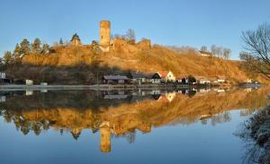 a castle sitting on top of a hill next to a lake at Penzion U Jezu Dobronice in Dobronice